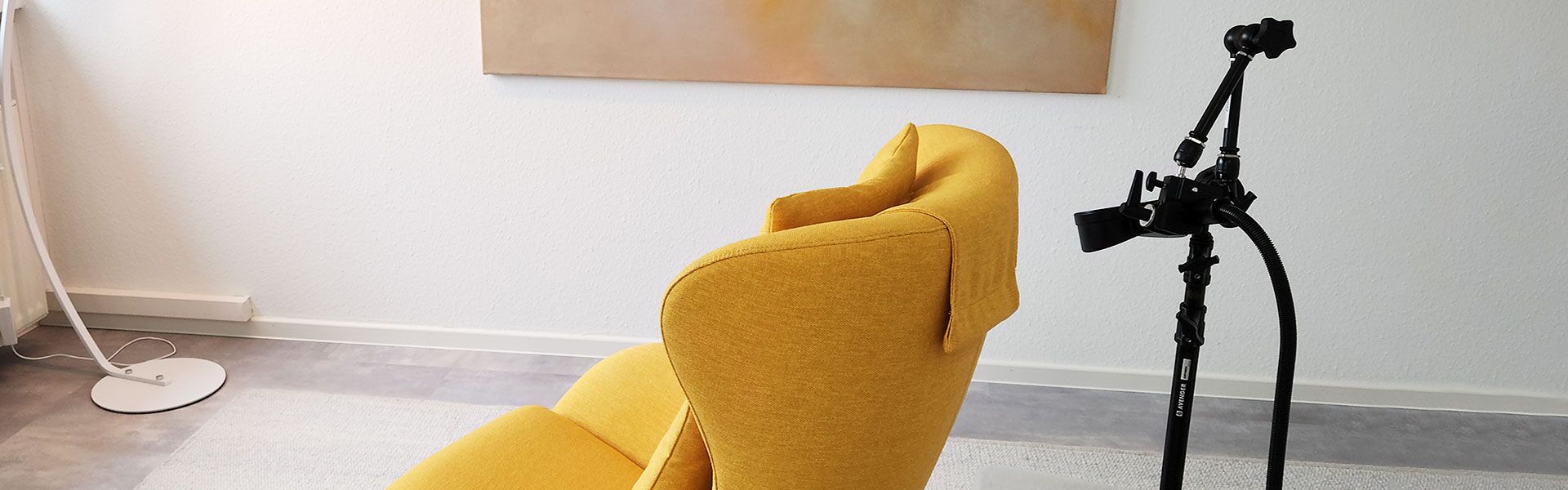 Behandlungszimmer mit gelben Sessel und dem rTMS Gerät